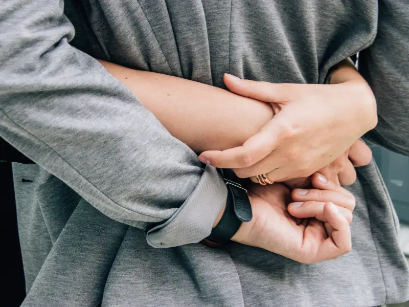 A close-up of a person’s hands clasped together, symbolising support for victims of domestic violence and abuse, focusing on care, protection, and emotional well-being.