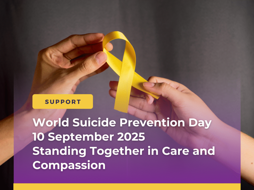Two hands holding a yellow awareness ribbon for World Suicide Prevention Day 2025 – standing together in care and compassion.
